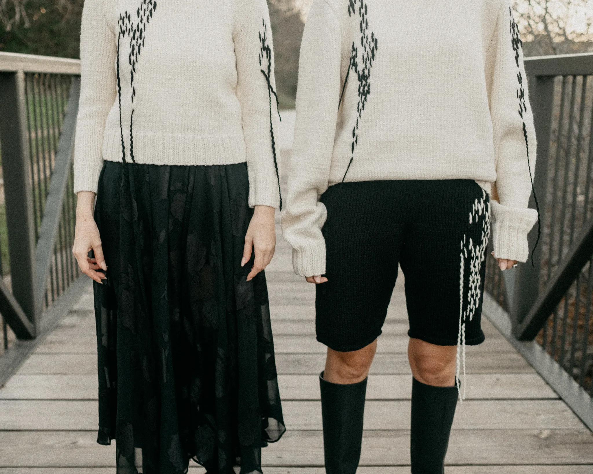 Close-up of Looking Friday cream Italian merino wool hand-knitted abstract sweaters with contrasting black organic stitch detailing.