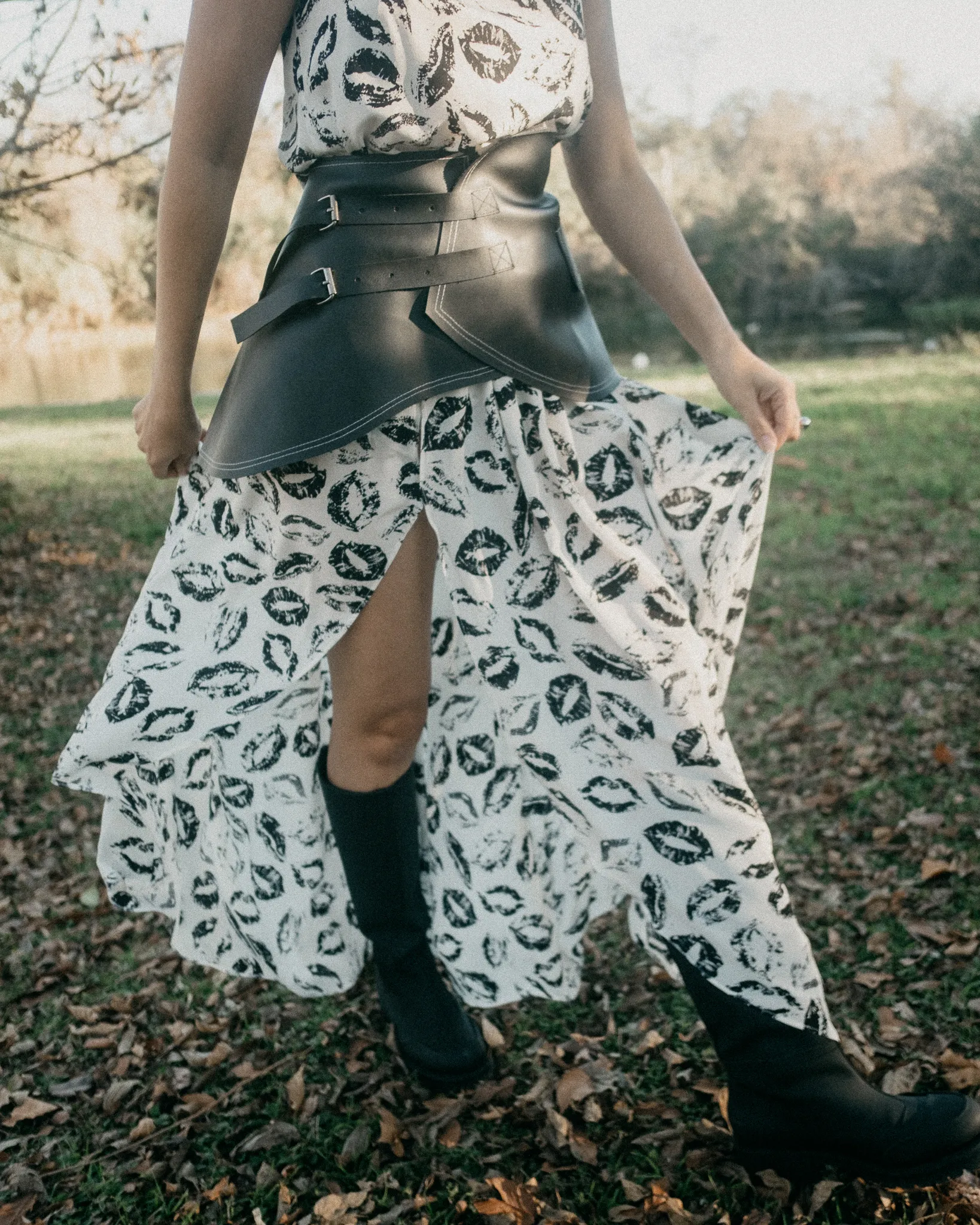 Close-up of Looking Friday black and white lipstick print silk maxi skirt styled with structured black cactus leather belt.