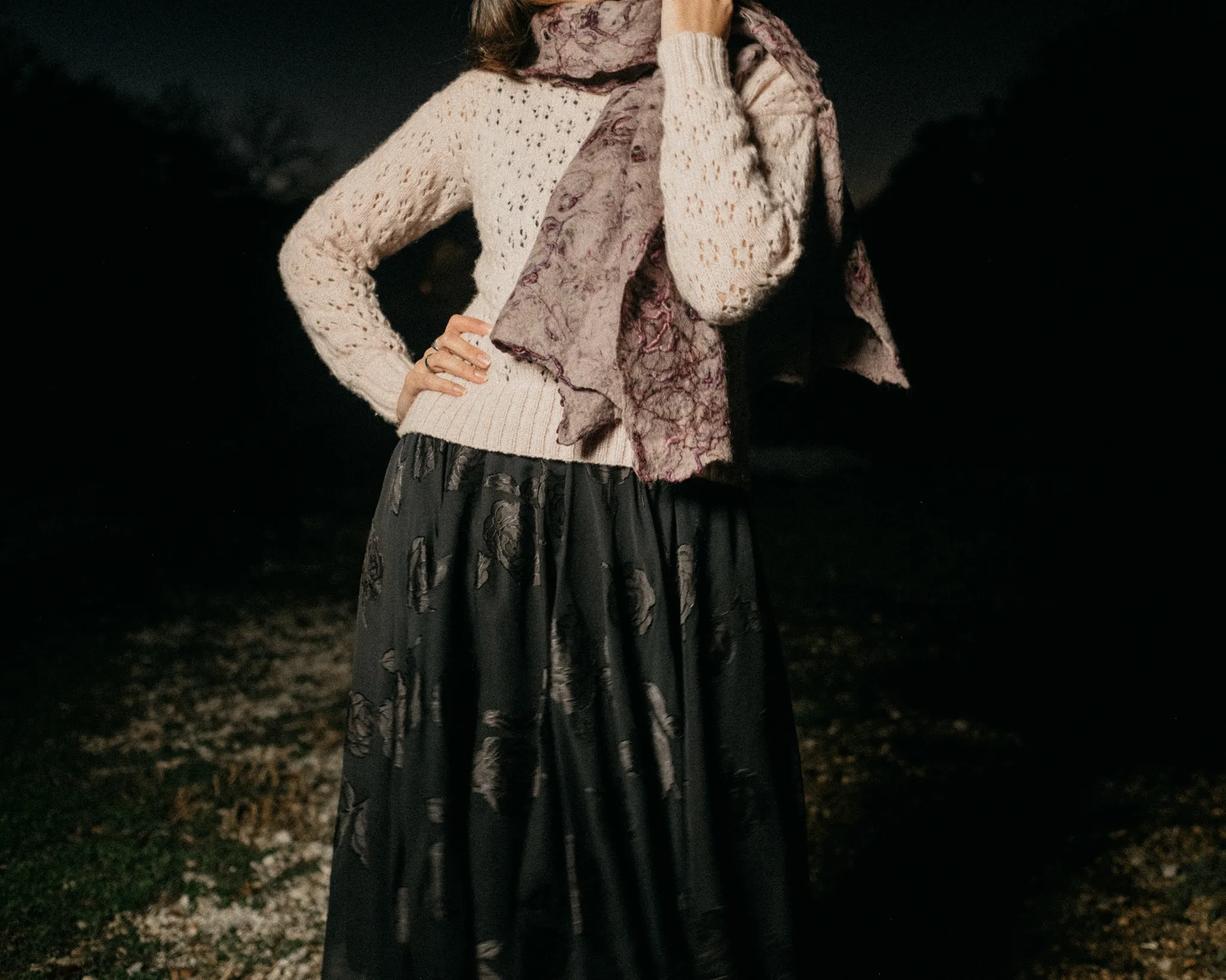 Model wearing Looking Friday cream open-knit lightweight cashmere sweater with printed scarf and black silk rose jacquard skirt