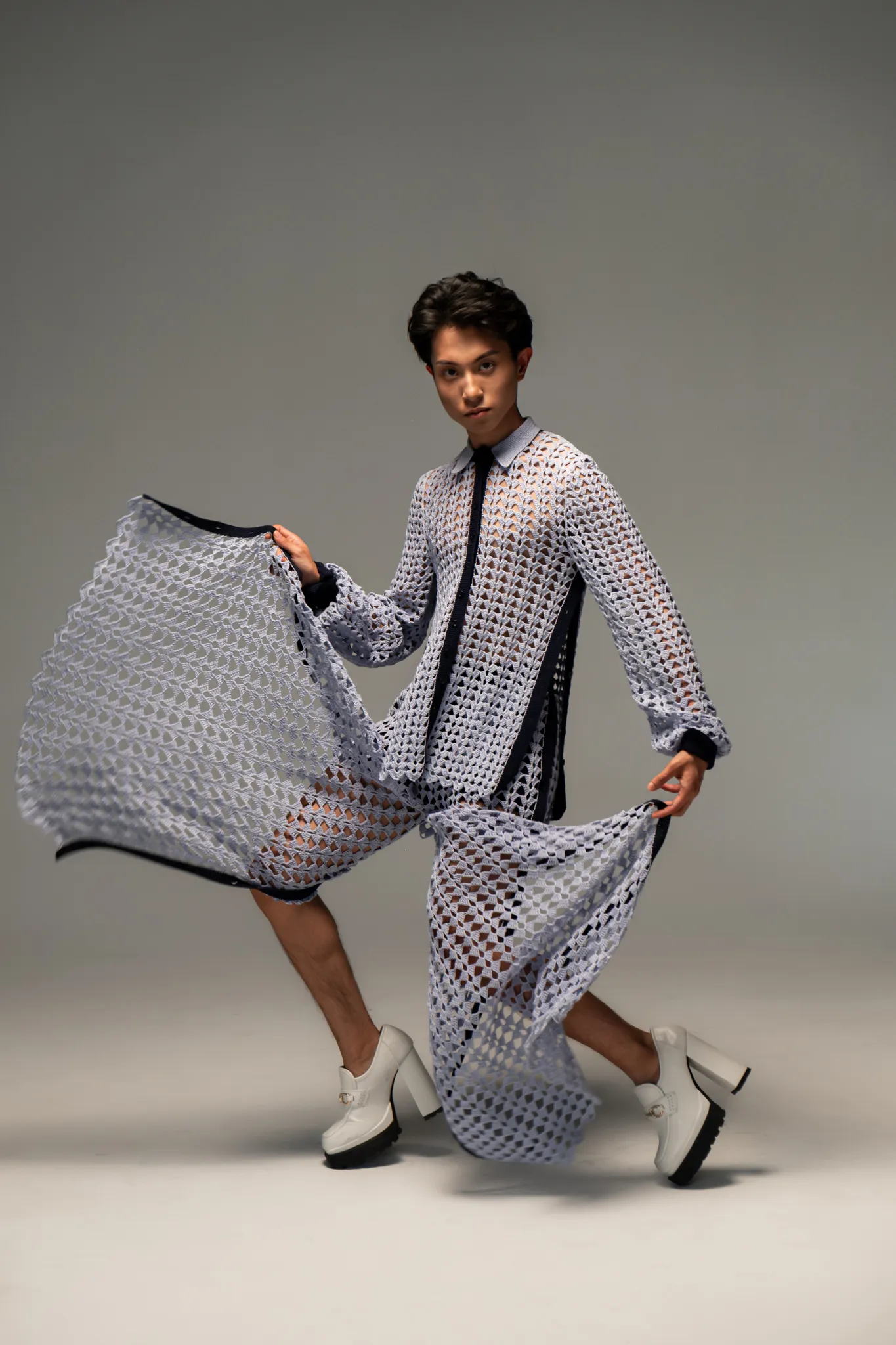 Model in Looking Friday slate blue Crochet Fan Dress Shirt and matching Crochet Fan Pants demonstrating the dramatic side-button slits in motion.